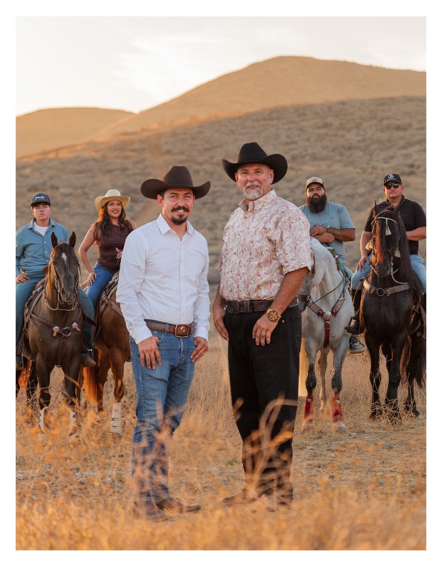 Chris Rosales standing with community members and riders on horseback in the Jurupa Valley hills